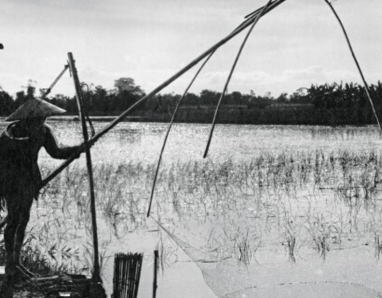 Photographie en noir et blanc avec un pêcheur au carrelet